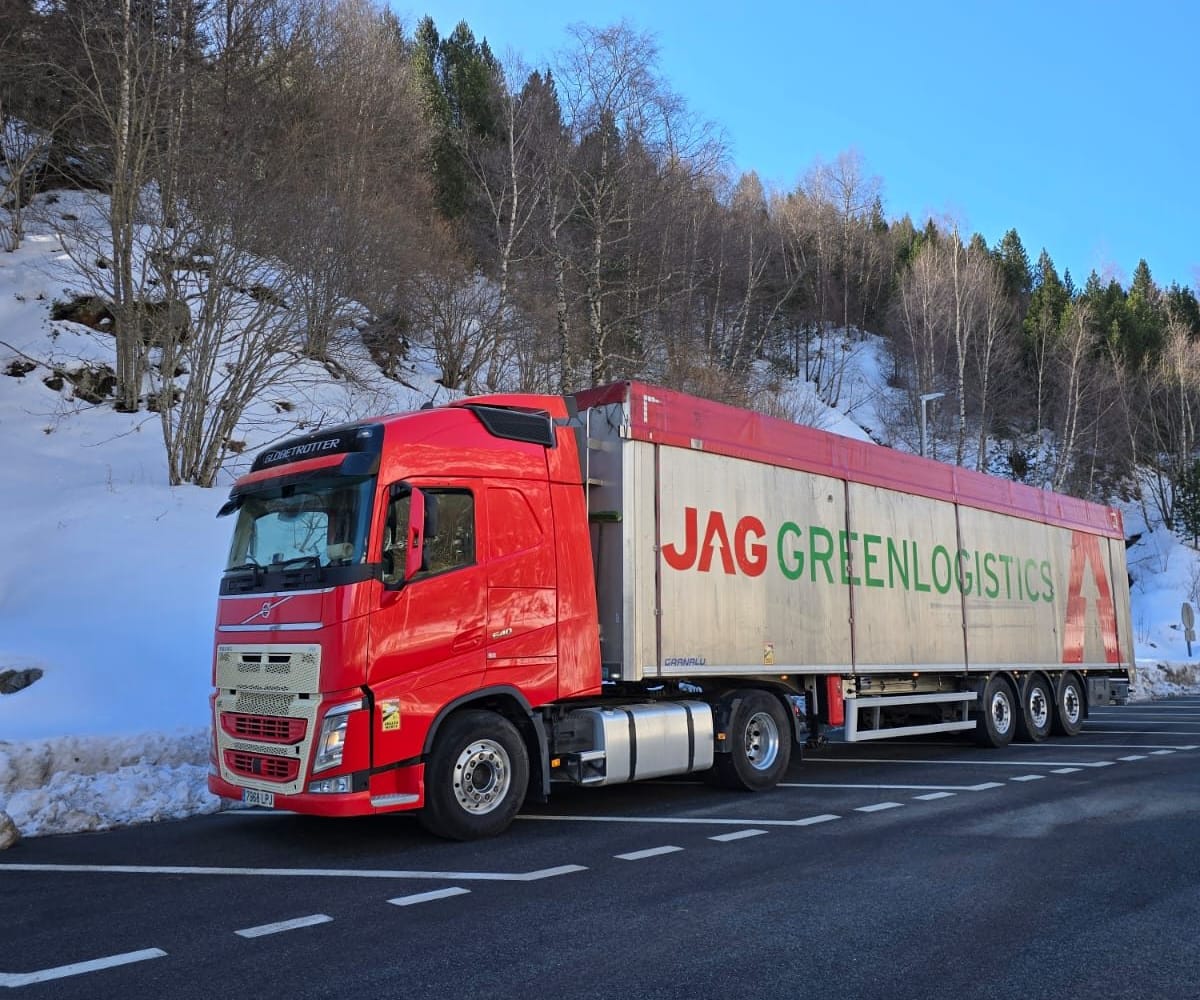 JAG truck with a moving-floor semi-trailer in a car park next to a snowy forest