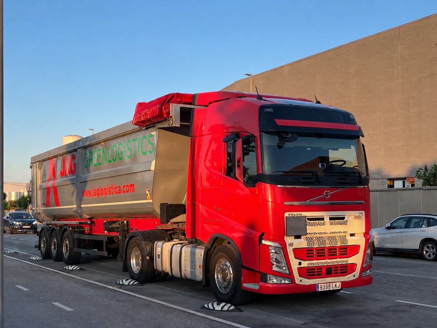 Red JAG truck with a tipper semi-trailer parked on an industrial estate