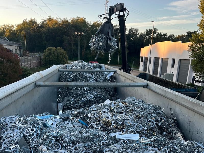 Semi-trailer loaded with metal scrap as a grab crane drops in more